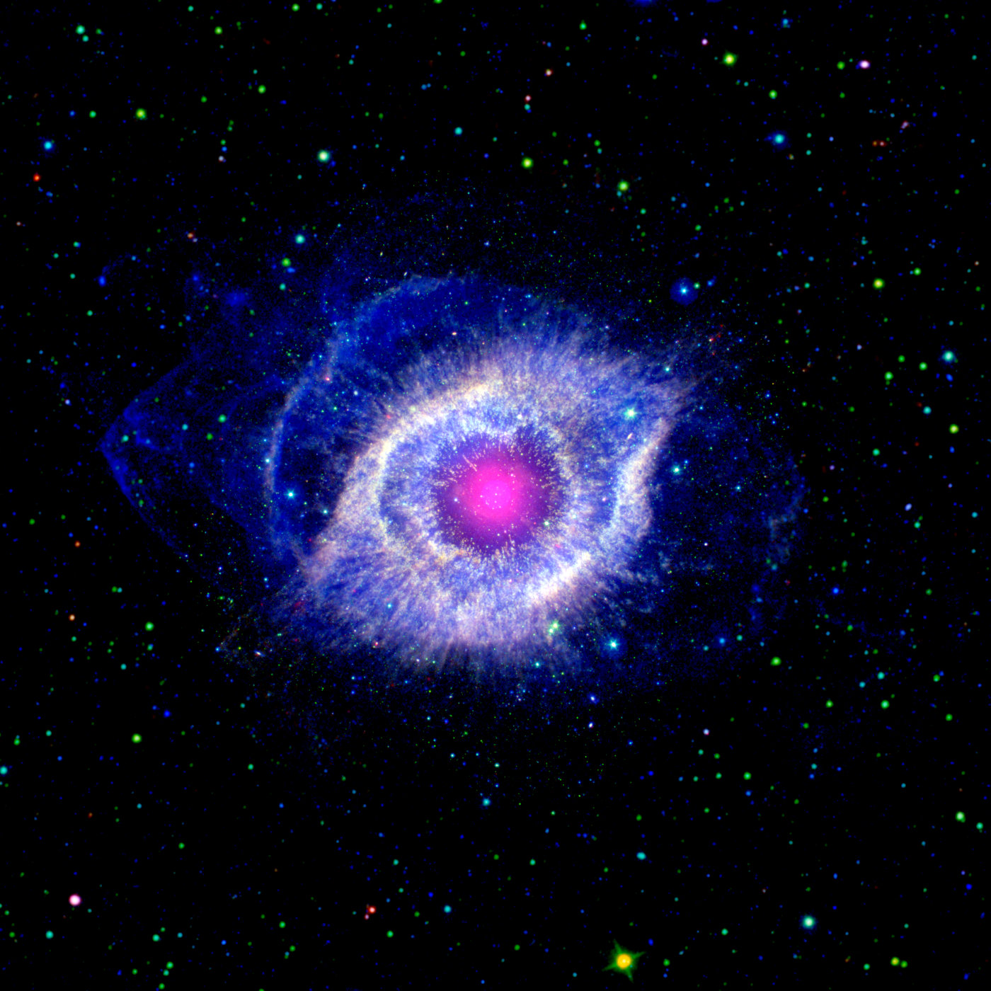 Ein Foto von NGC 7293, auch als Helixnebel bekannt. Der Nebel sieht aus wie ein riesiges blau-weißes Auge, das von leuchtend blauen Wolken umgeben ist. Den Hintergrund bildet das schwarze Weltall, gesprenkelt mit unzähligen, teilweise recht großen, grün-blauen Sternen. Im Inneren des Auges leuchtet wie eine Pupille kreisförmig ein rosafarbener Nebel.